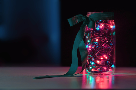 garland in the jar with colorfull ligh on the black backgroundの写真素材