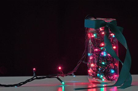 garland in the jar with colorfull ligh on the black background