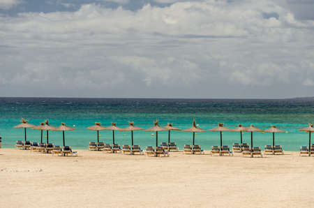poster. seascape. sand beach with umbrellas and chair. relax resort