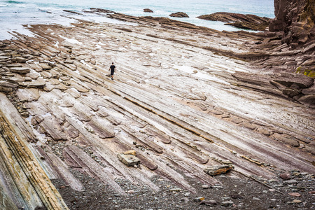 Man Alone at sea on a rocky shore, concept