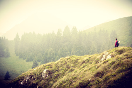 Woman alone in mountains, Person in countryside, Young woman looking into mountain landscape in summer, Strong woman in nature, Woman traveling world, Fulfill your dreamsの写真素材