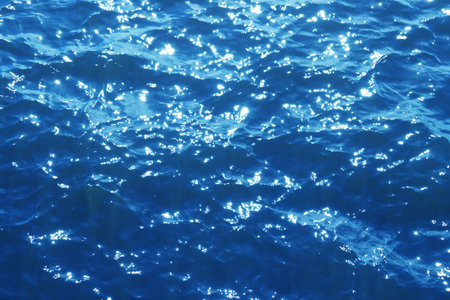 Blue water texture. Ocean and ripples on the water on a sunny summer day. High quality photoの写真素材