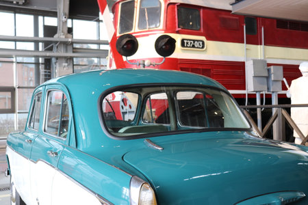 A small vintage retro car stands and train at a railway crossing. High quality photoの写真素材
