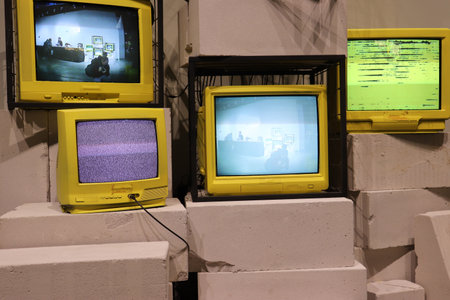 Several vintage yellow televisions stand nearby. Ripple and lost TV signal. High quality photoの写真素材