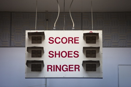 A horseshoe tournament scoreboard hangs from the ceiling