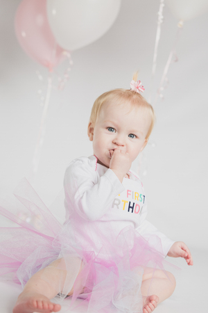 One year old girl birthday portraits with balloonsの写真素材