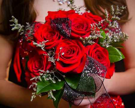 Close up of red rose prom bouquet with coordinating ribbon.の写真素材