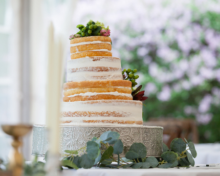 Wedding cake decorated for reception celebration. Layered cake is off center, falling sideways.の写真素材