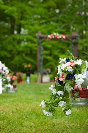Outdoor summer wedding venue path before the ceremony setup with flowers and wooden archwayの写真素材