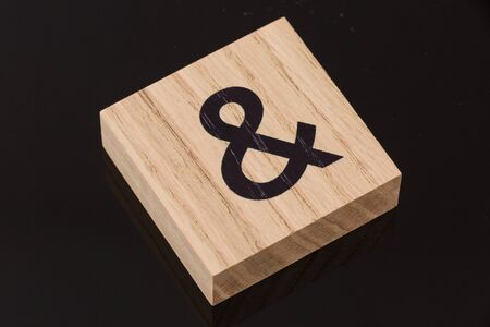 One ampersand symbol block tile on black background with reflection. Love concept.の写真素材