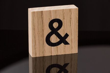 One ampersand symbol block tile on black background with reflection. Love concept.の写真素材