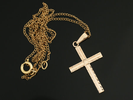 One shiny gold cross pendant on golden chain necklace. Religious jewelry. Christianity.の写真素材