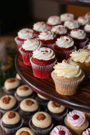 Multiple flavors of gourmet cupcakes on display stand at wedding reception eventの写真素材