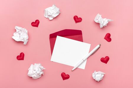 red envelope, white writing paper, hearts, pen, crumpled paper on pink background Happy Valentine's day concept, declaration of love Top view Flat lay Holiday Card Copy space Mock upの写真素材
