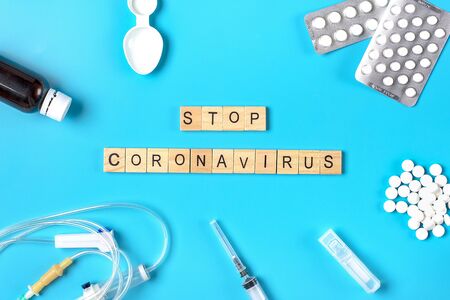 System for droppers, injection syringe, pills, cough syrup on blue background. Coronavirus word. Treatment, prevention, vaccination against coronavirus concept Top view Flat lay.の写真素材