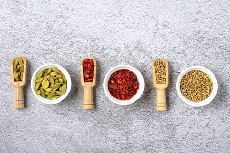 mix of aromatic spices coriander, bergamot, paprika in white cups on a gray concrete background Top view Flat lay Healthy food.の写真素材