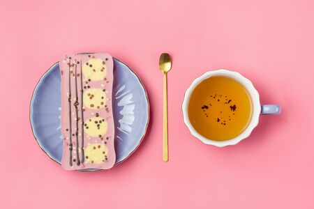 pink chocolate with raisins and nuts on lilac plate, cup of black tea, golden spoon on pink background Dessert Time concept Flat lay Top view.の写真素材