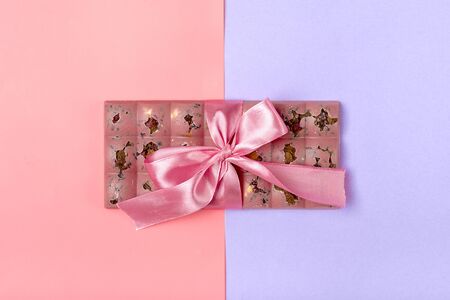 pink fruit chocolate with raisins and nuts on lilac and pink color background Dessert Time concept Flat lay Top view Candy shop.の写真素材