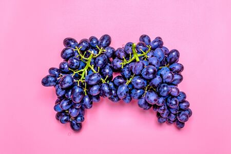 Natural organic black juicy grapes on a trend pink millennial background Top View Flat Lay.の写真素材