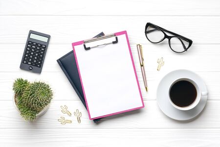 Fashion feminine home office workplace. Tablet, calculator, notepad, golden pen, clips, glasses, cup of coffee, succulent on white wooden background Top view Flat lay Freelance work, business conceptの写真素材