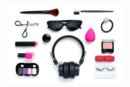 Set of professional decorative cosmetics, wireless headphones, makeup tools, accessory of trendy pink color isolated on white background Beauty, fashion, party, shopping concept Flat lay composition.の写真素材