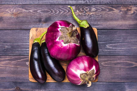 Purple Eggplant on blue plate on wooden background Top view Rustic style.