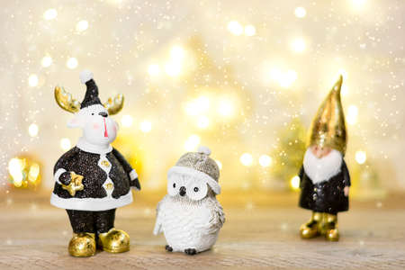 gnome, owl, moose decorated with sequin in black, golden color on bokeh background. Happy New Year, Merry Christmas concept Holiday card Flat lay Top view Scandinavian style Place for text.の写真素材