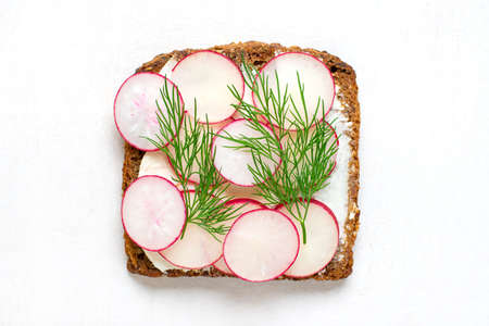 sandwich for breakfast - slice of whole grain dark bread, cream cheese, radish, garnished with dill...