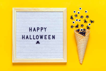 felt board with text and spiders on yellow background Top view Flat lay Happy Halloween creative...