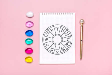 Horoscope circle with twelve signs of zodiac on paper, divination dice, colorful stone on pink background Fortune telling and astrology predictions Top view Flat layの写真素材