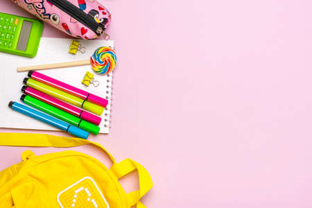 Back to school, education concept. Yellow backpack with school supplies - notebook, pens, clips,...