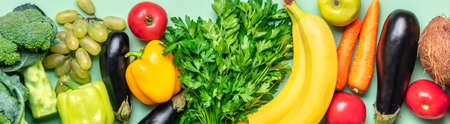 tabletop arrangement of variety of fresh fruits and vegetables sorted by colors-pepper, tomato, corn, carrot, green salad, cilantro, eggplant, cucumber, basil, dill, onion Healthy food concept.の写真素材