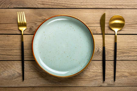 empty round gray plate, fork, knife, spoon on wooden table Top view Flat lay Dishes for breakfast, lunch or dinner Mock upの写真素材