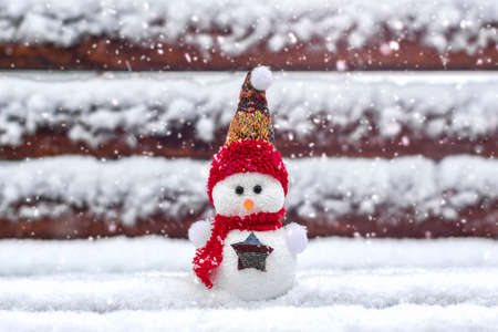 Merry christmas and happy new year greeting card with copy space Happy little snowman in red cap and scarf standing in winter snow background Xmas fairytale Hello January, February conceptの写真素材