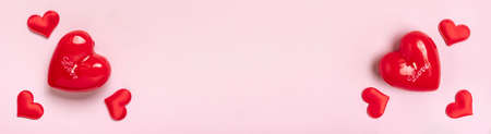 frame of heart shaped candle red hearts layout on pink background Top view Flat lay Holiday card Happy Valentine's day, love concept Copy space Banner.の写真素材