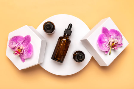 glass cosmetic bottle with moisturizing natural oil, Orchid lie on white podium isolated on beige background Top view Flat lay Eco, bio, zero waste product concept Copy space Mock up.の写真素材