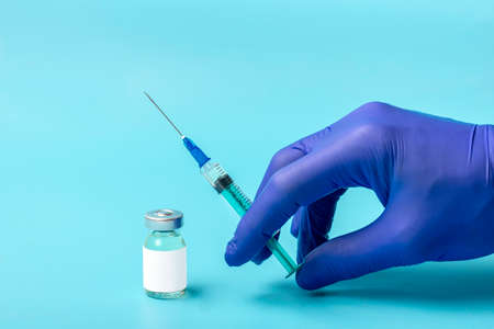 Ampoule with vaccine, syringe isolated on blue background Vaccination against viruses, flu, pneumonia, coronavirus, tuberculosis, covid-19 concept Mock-up Top view Flat Lay.の写真素材