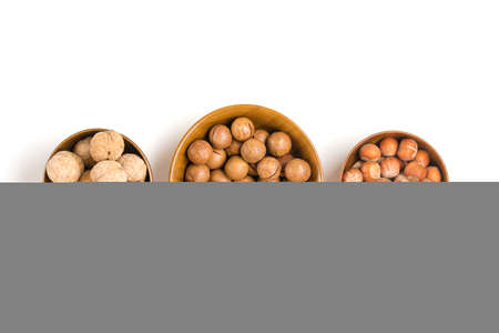 natural organic macadamia, walnut, hazelnut nuts in wooden bowl on white background Flat lay Top view Healthy snack Nuts with essential oil rich in vitamins B, PP, lot of fats and high in calories Superfood.の写真素材