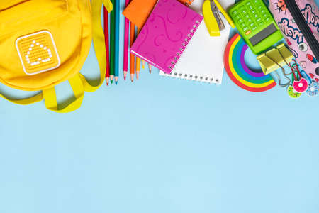 Back to school, education concept Yellow backpack with school supplies - notebook, pens, eraser...
