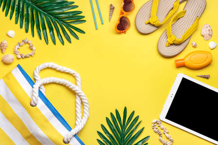 Swimming accessories - trendy beach bag with stripes, black glasses, white tablet, palm leaf, yellow...