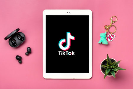 Bangkok, Thailand. October 2022 Tablet Tik Tok application icon, logo on screen and wireless headphones on colorful background Trendy social media network concept Flat lay Top view.のeditorial素材