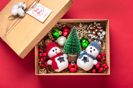 Handmade care package, seasonal gift box with toys, xmas decor on red table Personalized eco...