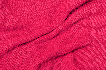 The texture of warm knitted sweater. Beautiful handmade knitted pattern. Demonstrating color of the year 2023 viva magenta.の写真素材