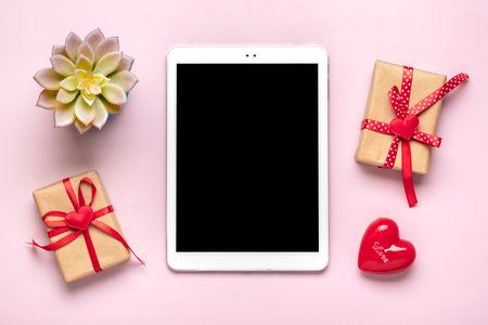 digital tablet for chooses gifts, makes purchase, red hearts on pink table Top view Flat lay Holiday shopping list, Happy Valentines day, party, online shop concept Mockup.の写真素材