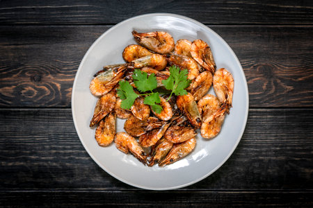 fried shrimp with soy sauce, garlic in gray plate on wooden table Seafood Traditional thai food.の写真素材