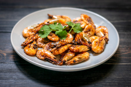 fried shrimp with soy sauce, garlic in gray plate on wooden table Seafood Traditional thai food.の写真素材