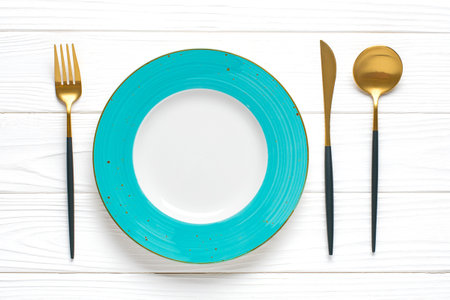 empty round blue plate, fork, knife, spoon, sprig of eucalyptus on wooden table Top view Flat lay Dishes for breakfast, lunch or dinner Mock up.の写真素材