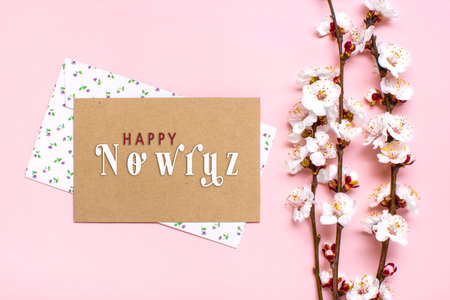 Sprigs of the apricot tree with flowers on pink background Text Happy Nowruz Holiday Concept of spring came Top view Flat lay Hello march, persian new year.の写真素材