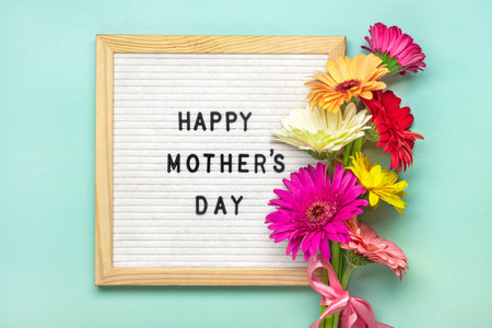 Felt board with text Happy Mothers day, colorful gerberas bouquet on green backround greeting holiday card Flat lay Top view.の写真素材