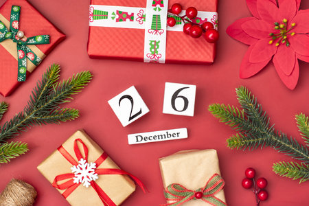 Gift boxes, wooden calendar with date December 26 on red background Boxing